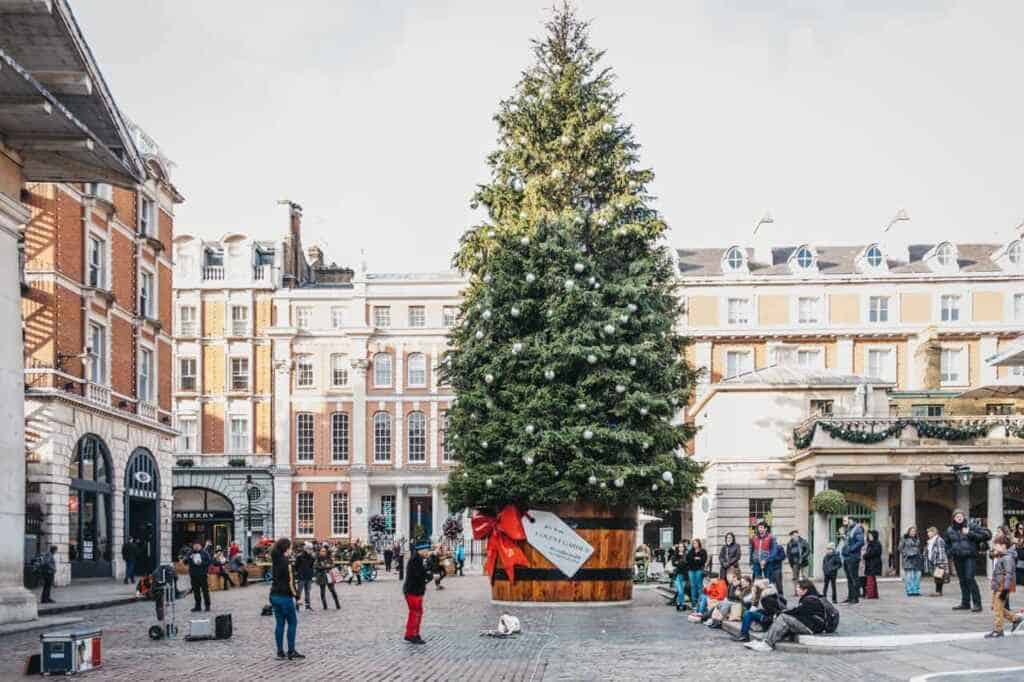 London, UK - November 21, 2018: Giant Christmas tree in a pot with a gift tag in front of Covent Garden Market, one of the most popular tourist sites in London, UK.