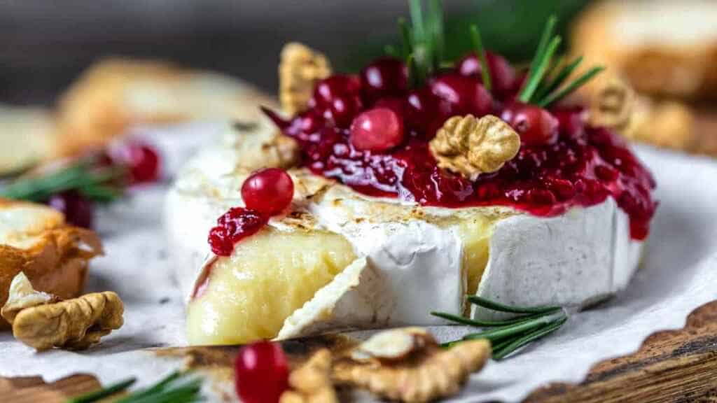 Baked or fried grilled Camembert or brie cheese with berry sauce or jam. Gourmet traditional Breakfast close up