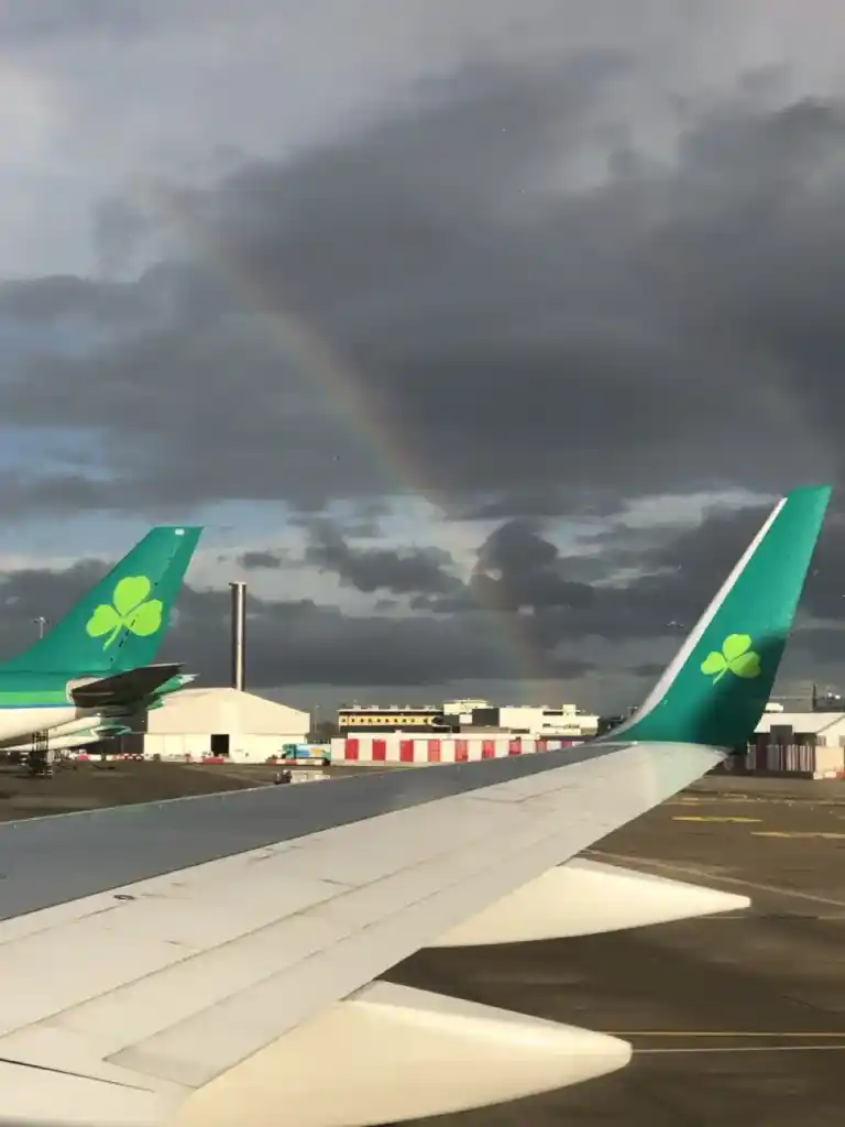 Aer Lingus planes on the tarmac. A rainbow is visible over the wing.