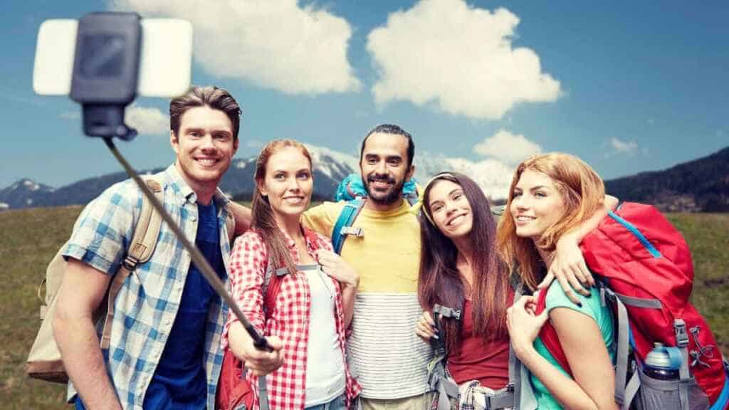 Friends with backpack taking selfie by smartphone