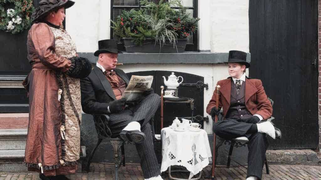 Actors dressed in Victorian costumes performing from A Christmas Carol by Charles Dickens