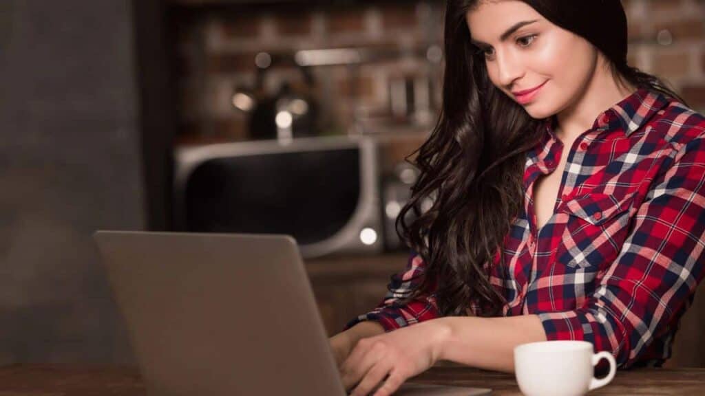 Young woman working a laptop with a cup of coffee