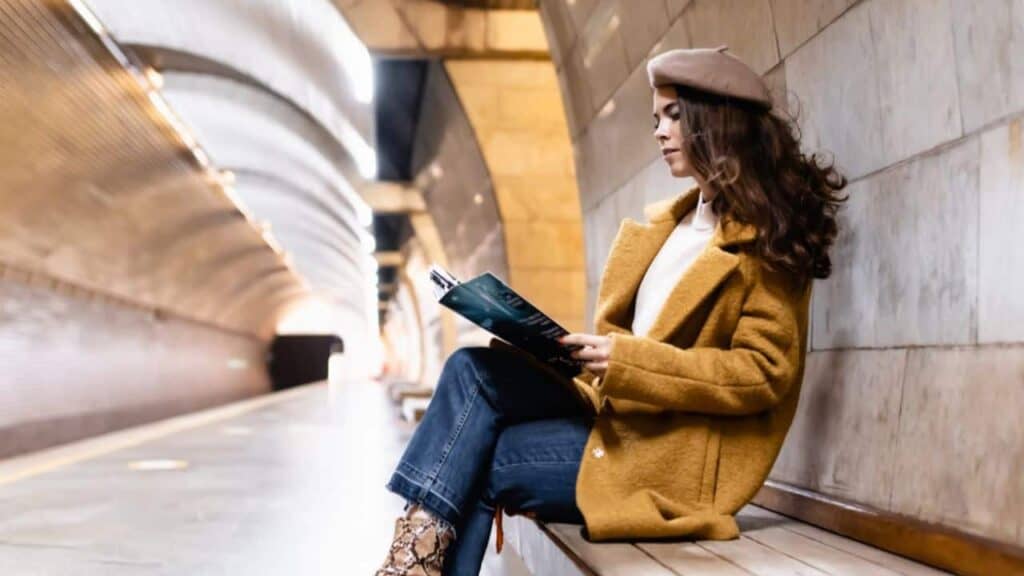 Woman waiting for the metro reading a magazine