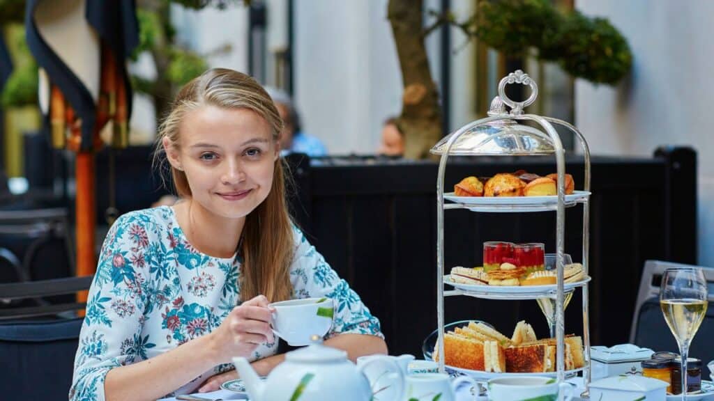 Afternoon Tea with a girl holding a tea cup at the table