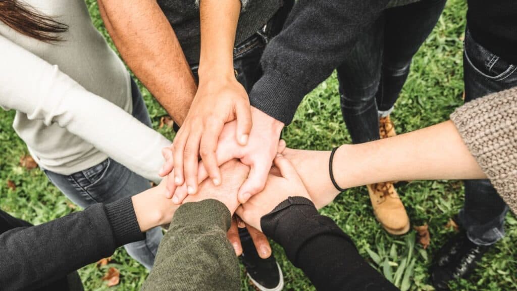 Group of volunteers with their hands in a circle