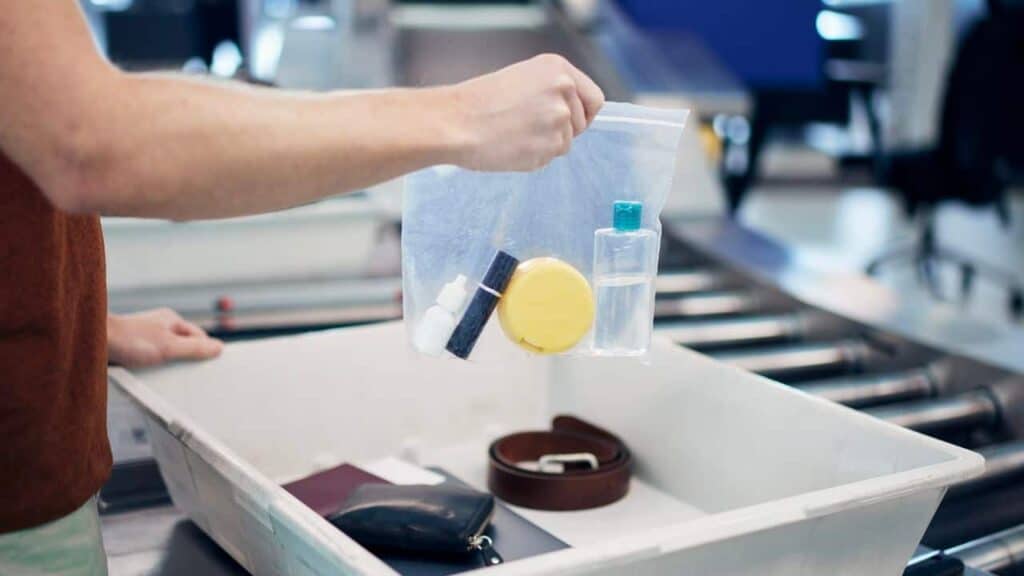 Clear bag with liquids and bin in airport security line.