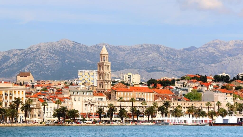 Promenade in Split, Croatia with landmark architecture and sailing boats.