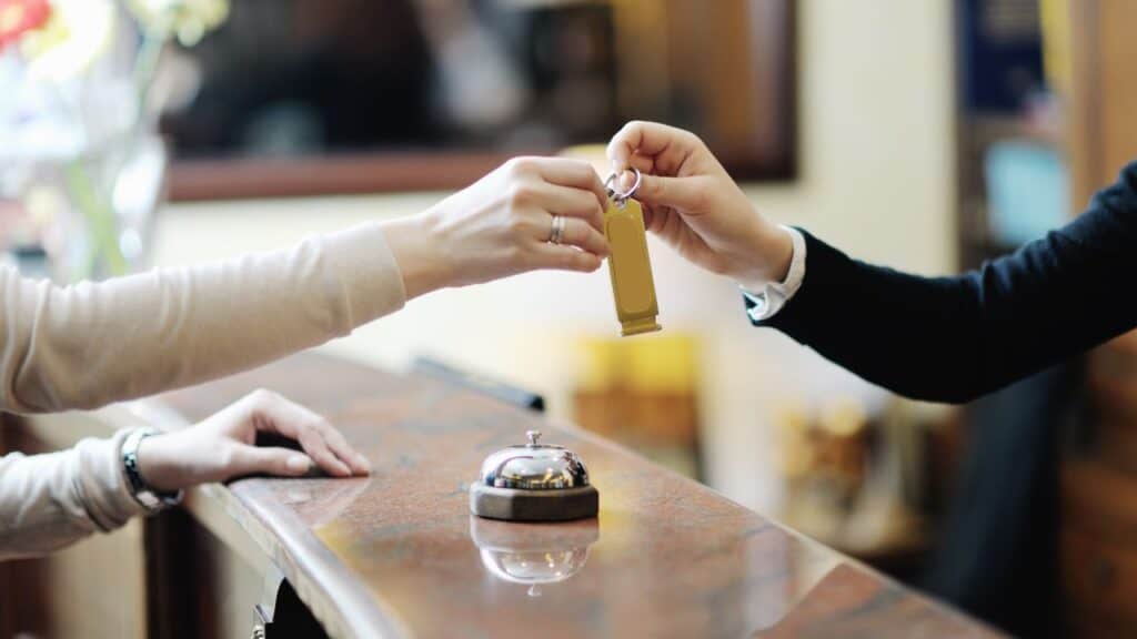 Someone checking in to a hotel and being handed their key.