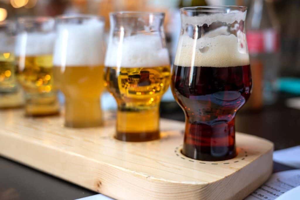 Brewery tasting with five glasses of different color and opacity of the drink. Blurred and indistinguishable background of the brewery.