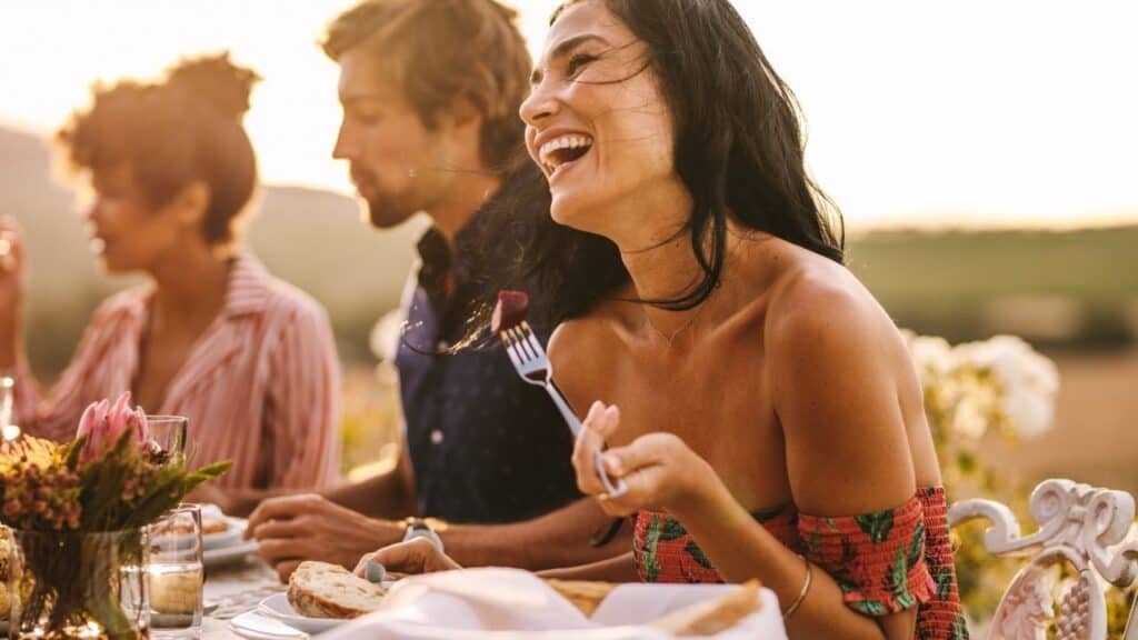Woman Enjoying with Friends at Outdoor Dinner Party; Food Allergy Travel