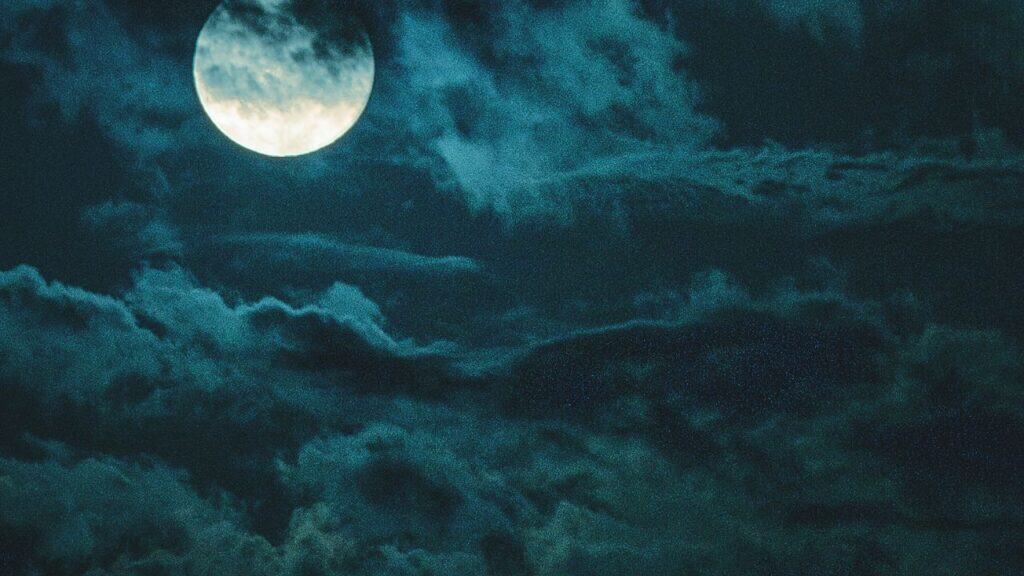 Full moon on spooky cloudy sky